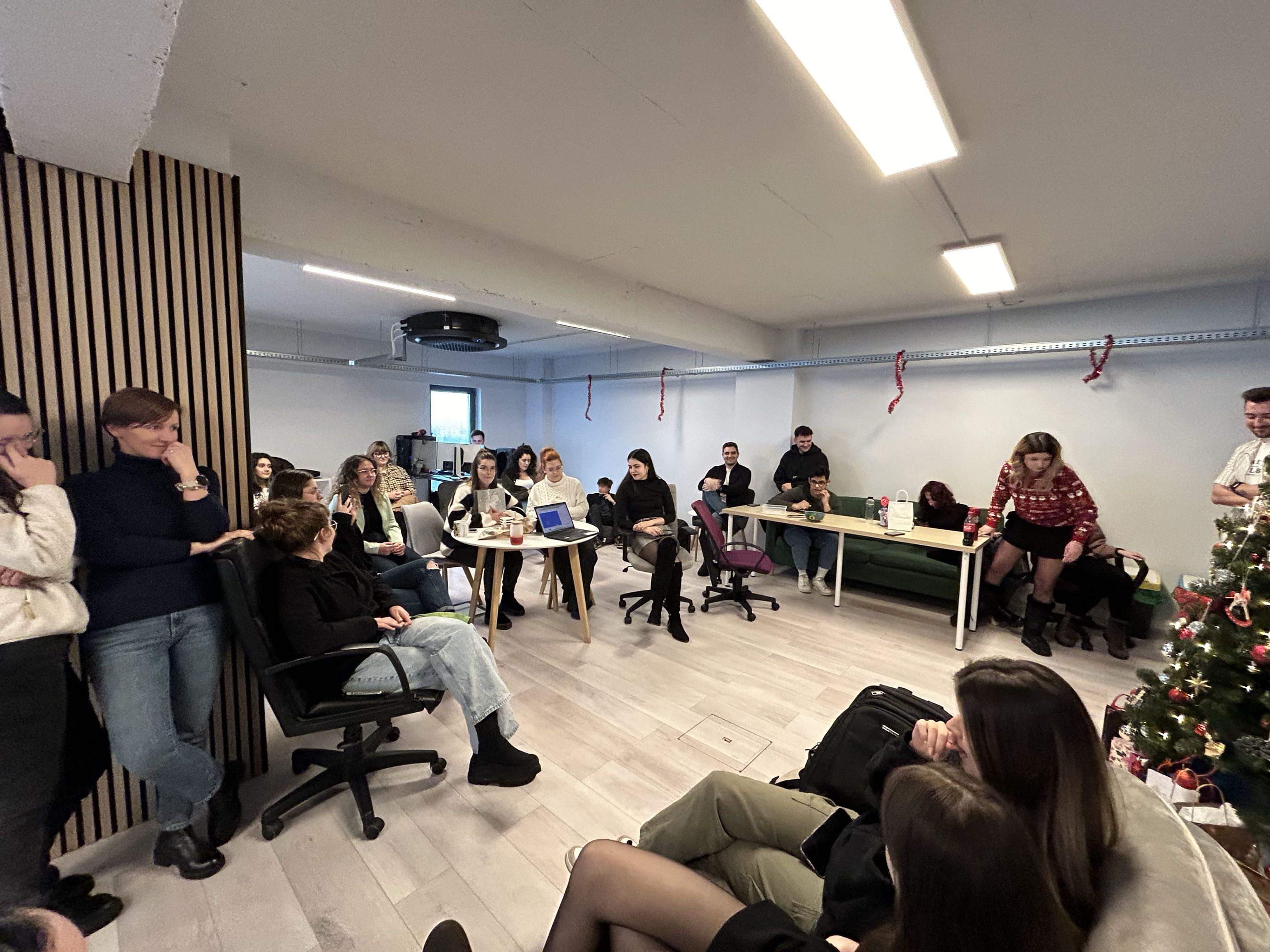 Christmas gathering with 25 plus people around the office tree