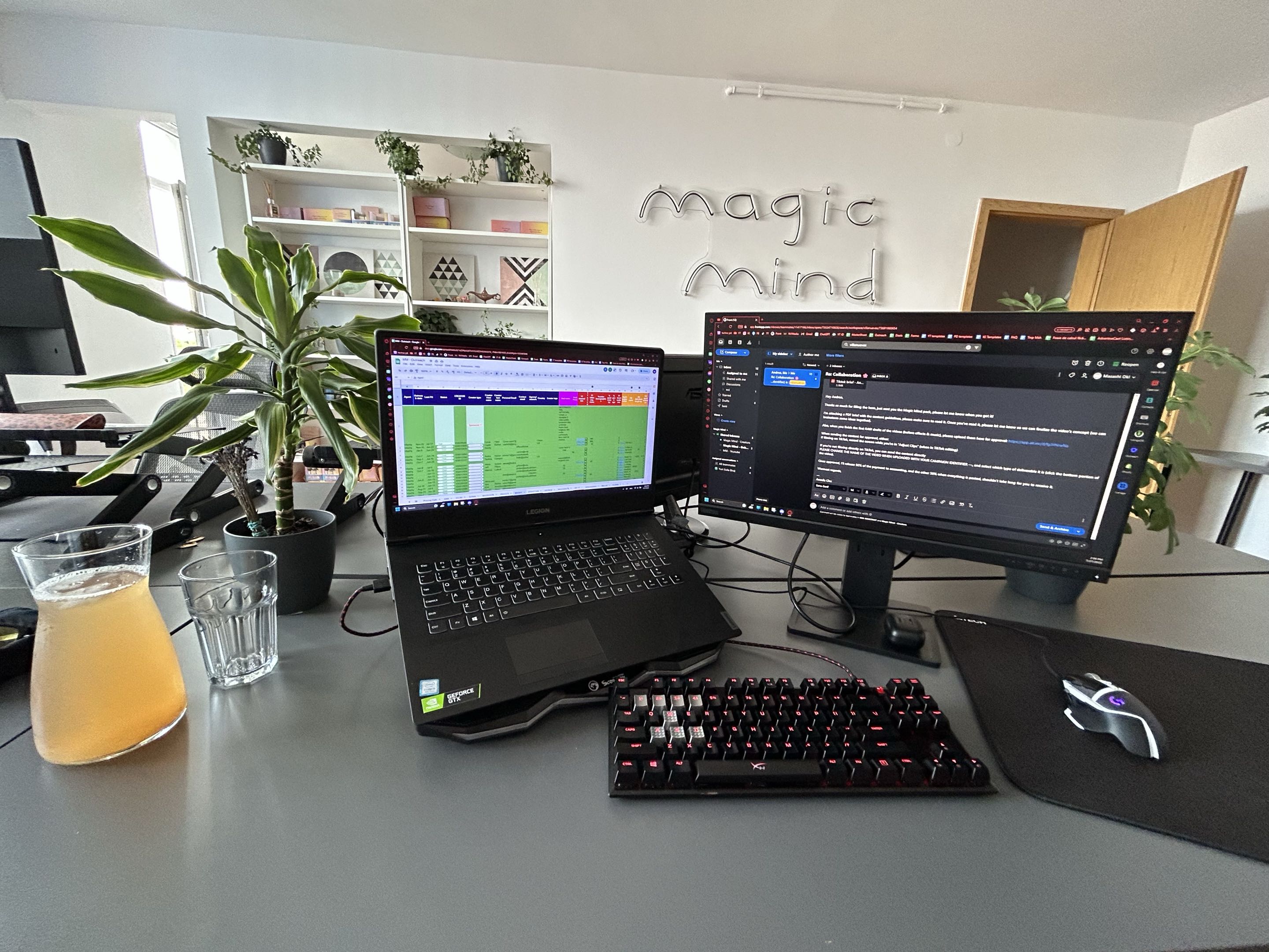 Workstation with Magic Mind neon lettering on wall - the working office