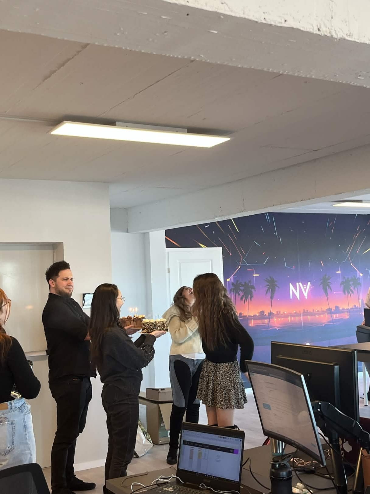 Birthday celebration in the new office, NV wall mural visible