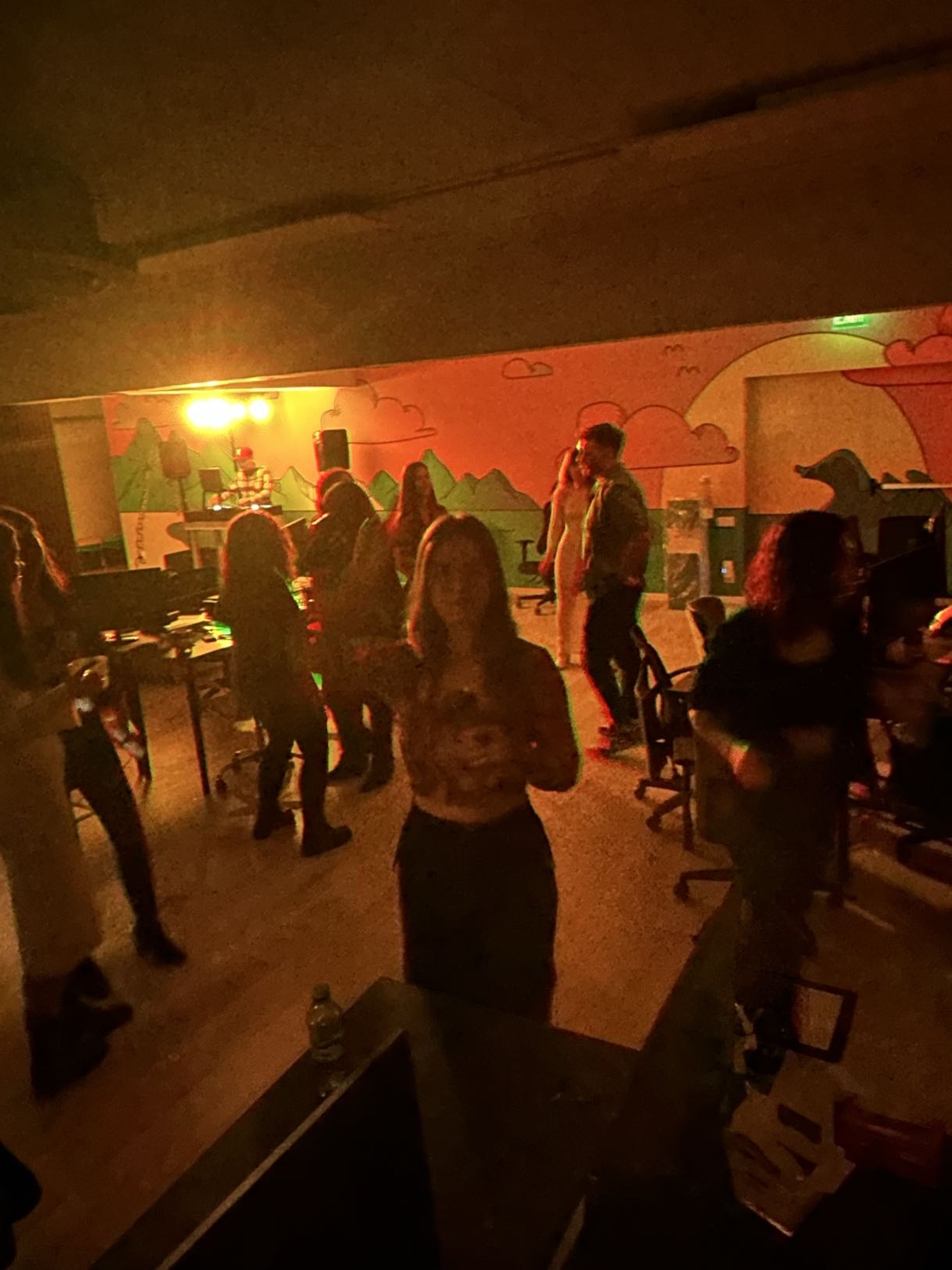 Office party under red lighting, team dancing